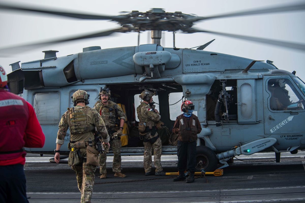 In this photo provided by the U.S. Navy, sailors assigned to an explosive ordnance unit board an MH-60S Seahawk helicopter on the flight deck of aircraft carrier USS Ronald Reagan to head to an oil tanker that was attacked off the coast of Oman in the Arabian Sea on Friday, July 30, 2021. An attack on an oil tanker linked to an Israeli billionaire killed two crew members off Oman in the Arabian Sea, authorities said Friday, marking the first fatalities after years of assaults targeting shipping in the region.  (Mass Communication Specialist 2nd Class Quinton A. Lee)