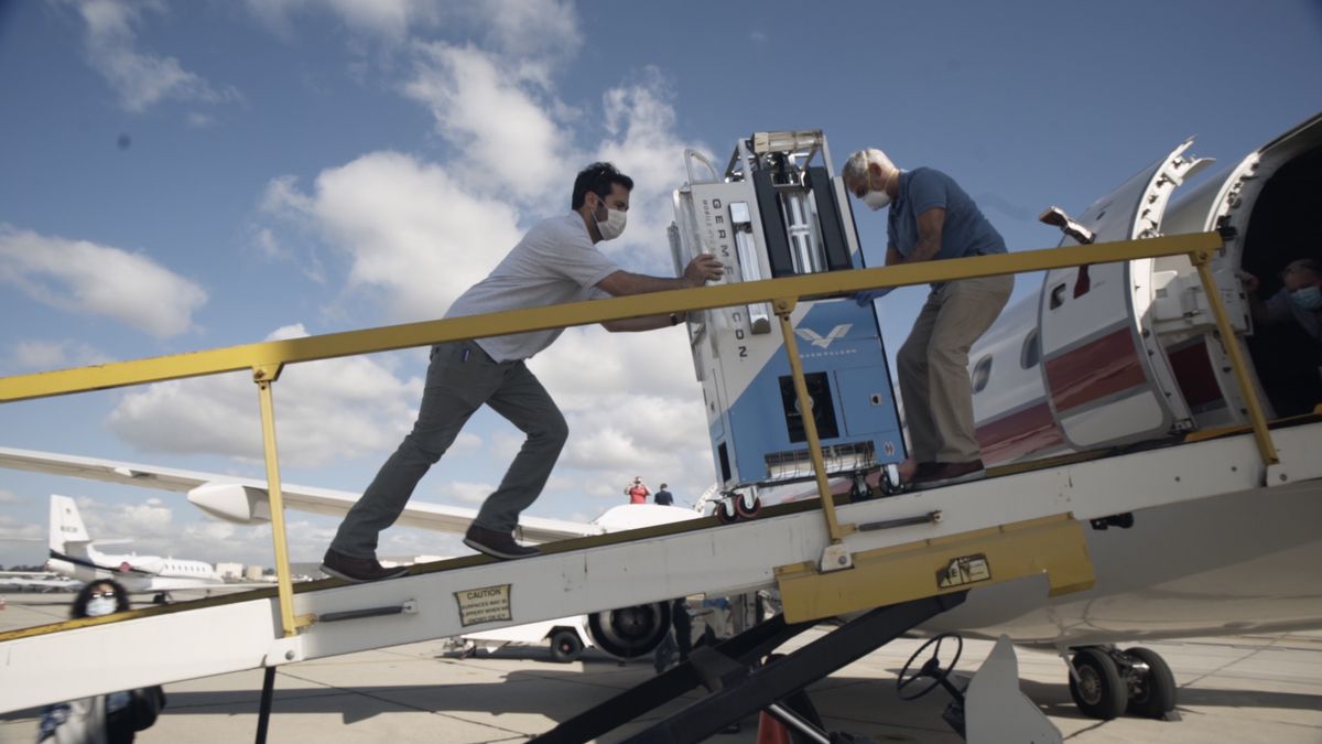 Elliot and Arthur Kreitenberg push the GermFalcon onto a plane to disinfect the cabin.  (Tribune News Service photos)