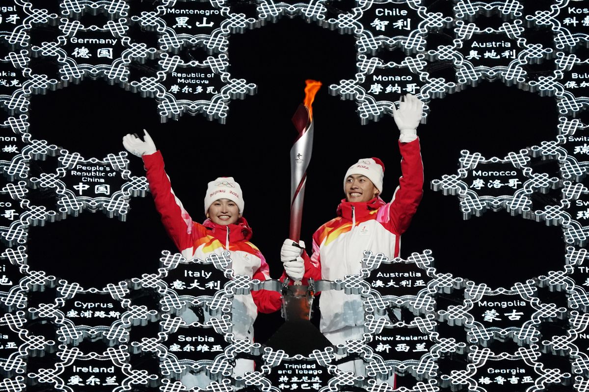 Olympic torch is brought into the stadium by Dinigeer Yilamujian and Zhao Jiawen during the opening ceremony of the 2022 Winter Olympics, Friday, Feb. 4, 2022, in Beijing.  (Jae C. Hong)
