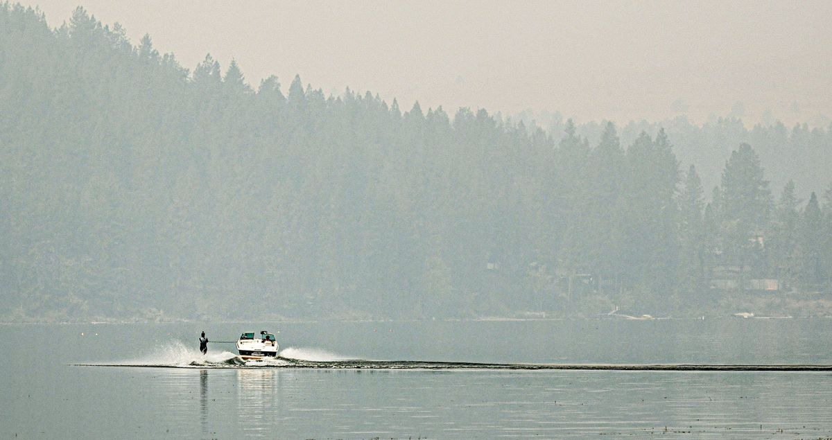 A water skier braves the smoke from area fires while skimming the surface of Liberty Lake on Monday, Sept. 12, 2022.  (Kathy Plonka/The Spokesman-Review)