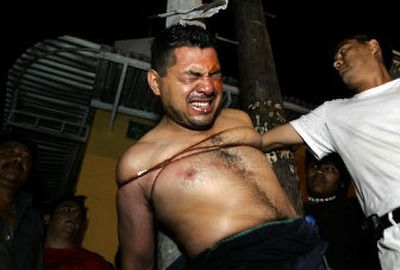 
Police officer Manuel Dominguez is tied to a pole after residents of a neighborhood accused him of trying to burgle a house in the city of Oaxaca, Mexico, on Tuesday.
 (Associated Press / The Spokesman-Review)
