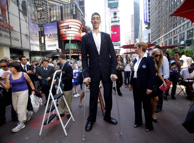 ORG XMIT: NYSW102 The world's tallest man, Sultan Kosen of Turkey, poses in New York's Times Square, Monday, Sept. 21, 2009.  Kosen has been verified by the Guinness Book of World Records as the world's tallest living man at 8 foot 1 inch.   (AP Photo/Seth Wenig) (Seth Wenig / The Spokesman-Review)