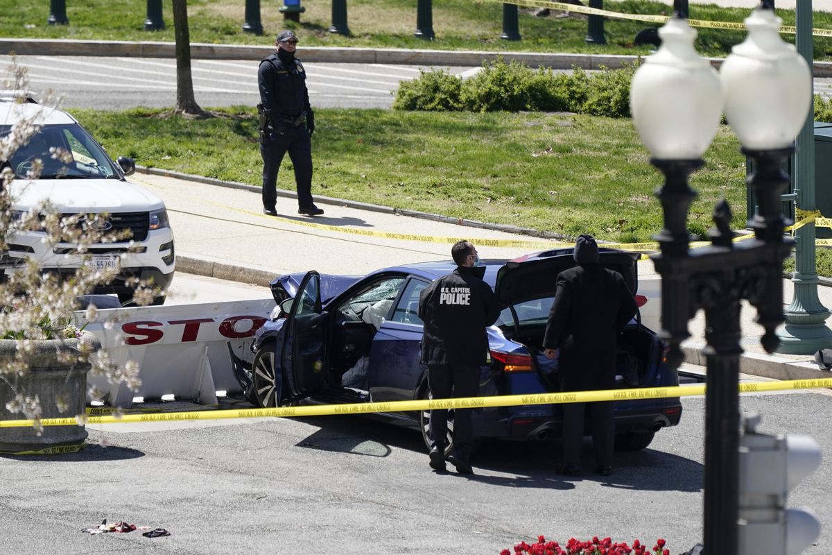 U.S. Capitol Police officers stand near a car that crashed into a barrier Friday in Washington.  (J. Scott Applewhite)