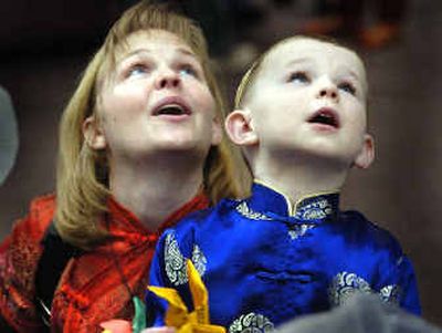 
Brendan Perdue and his mother, Kim, watch a folded paper plane take flight at the Year of the Rooster Celebration held by the Spokane Chinese Association at SCC on Saturday. Brendan's parents plan to adopt a Chinese baby this fall. 
 (Christopher Anderson/ / The Spokesman-Review)