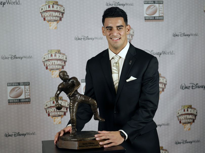 Oregon’s Marcus Mariota stands with his trophy after being awarded the Davey O'Brien Award for the nation’s top quarterback. (Associated Press)