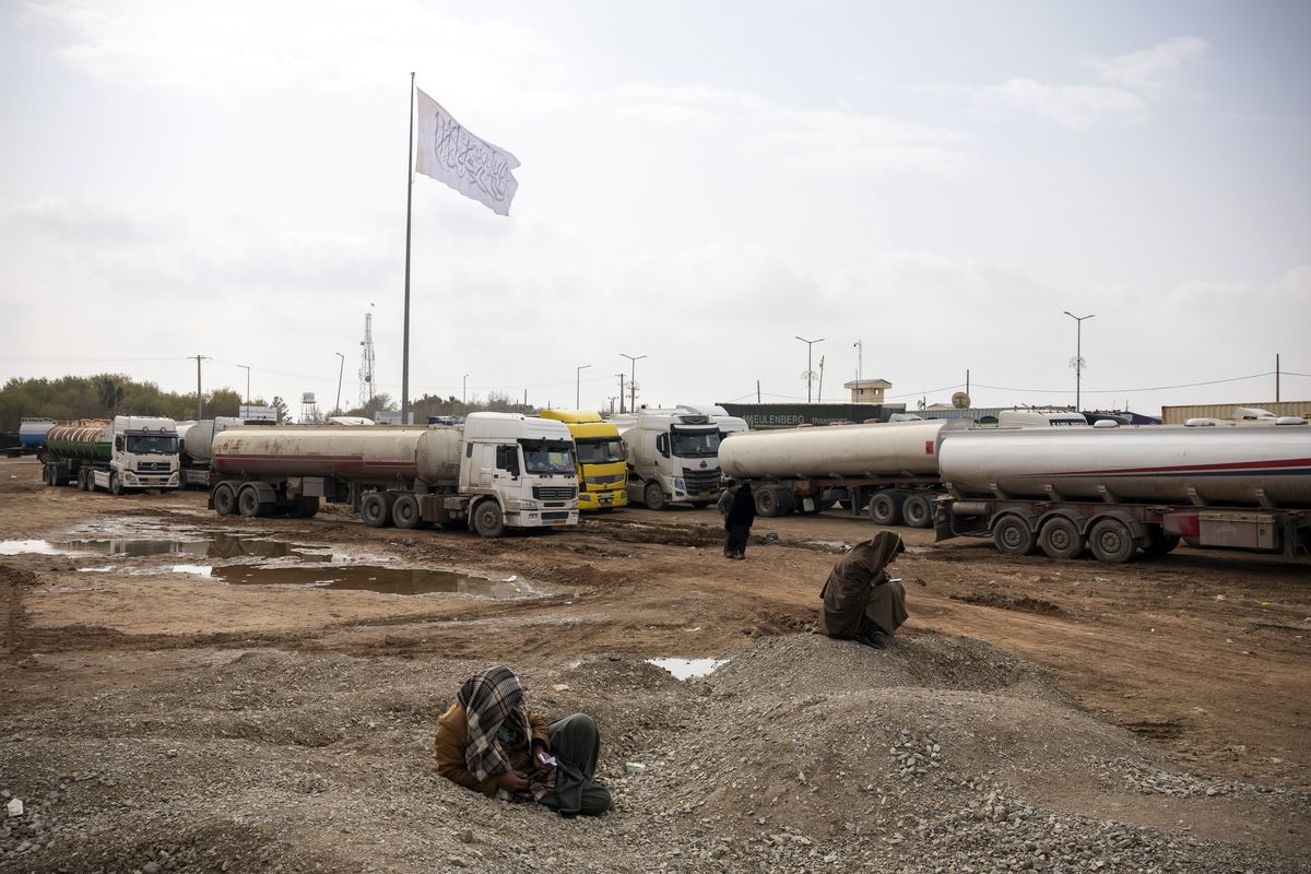 A man waits for a cell phone signal at the border crossing at Islam Qala, Afghanistan, to contact his brother, who drives a truck between Afghanistan and Iran, on March 18, 2026. The war in Iran is choking off Afghanistan