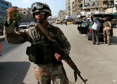 
An Iraqi soldier directs traffic at a vehicle checkpoint in central Baghdad on Wednesday. 
 (Associated Press / The Spokesman-Review)