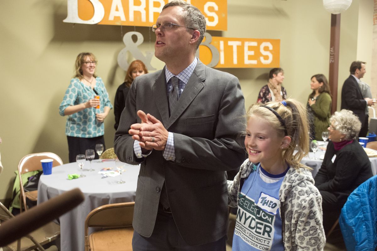 Incumbent Spokane City Council member Jon Snyder talks with the media, with daughter Theo, 9, at his side at the Spokane Public Market building Tuesday. He was re-elected handily over challenger John Ahern. (Jesse Tinsley)