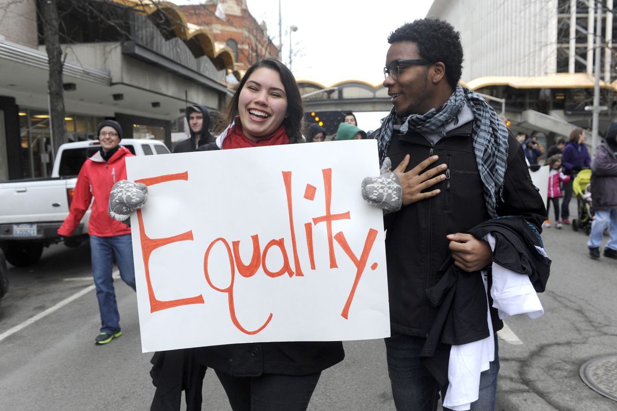 Jasmyne Bivens, left, and Javontae McCain, both 17 and classmates at On Track Academy, walk in the annual Martin Luther King Jr. Day march as it moves west from the Spokane Convention Center toward River Park Square. (Jesse Tinsley)