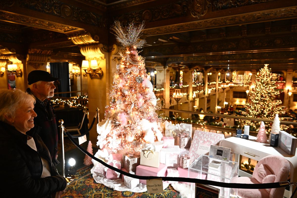 Carolyn and Frank Walchak take in the pink-trimmed holiday tree titled “Glittering Once Again” sponsored by Plastic Surgery Northwest on the balcony surrounding the lobby of the Historic Davenport Hotel on Wednesday at Christmas Tree Elegance, a major fundraiser for the Spokane Symphony Associates. (Jesse Tinsley/THE SPOKESMAN-REVI)