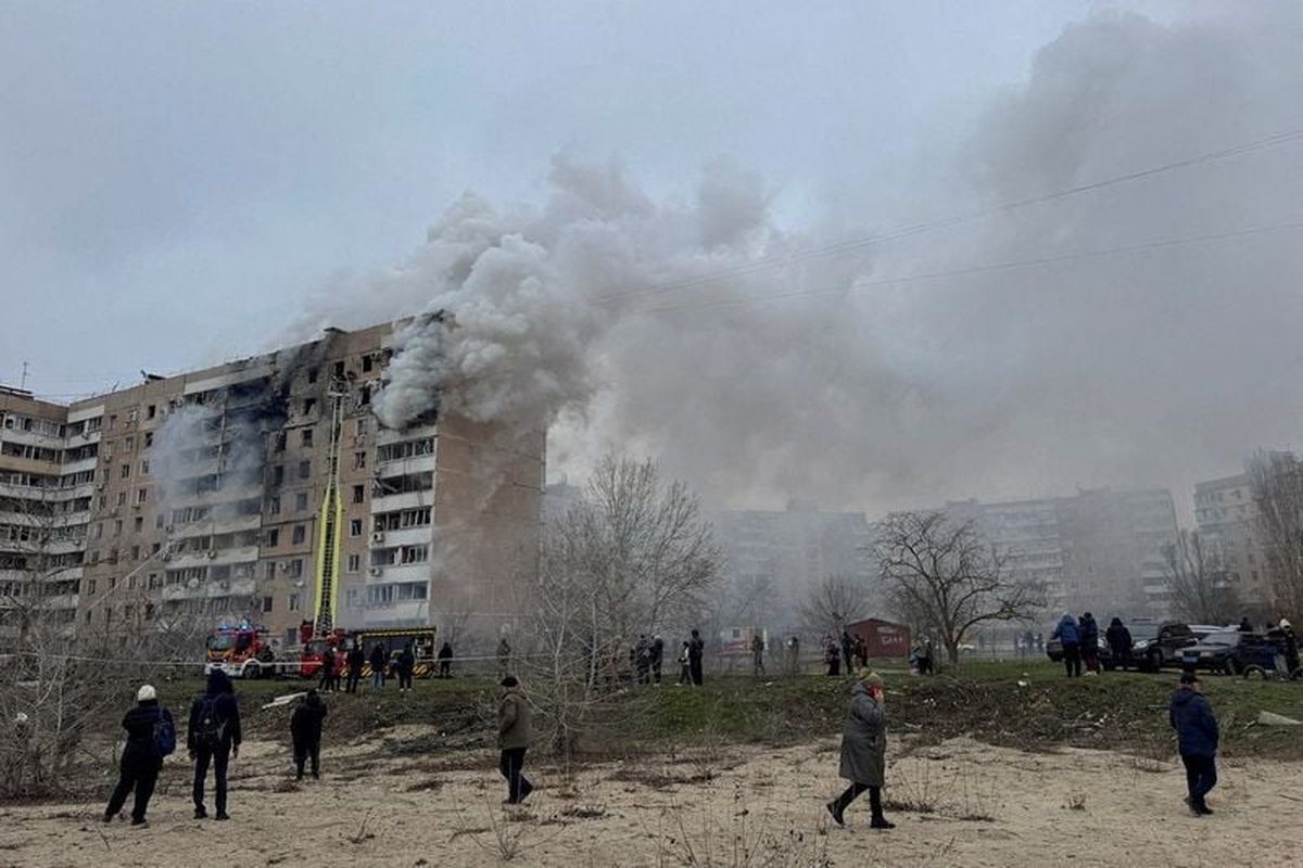 FILE PHOTO: Residents walk in front of an apartment building hit by a Russian air strike, amid Russia