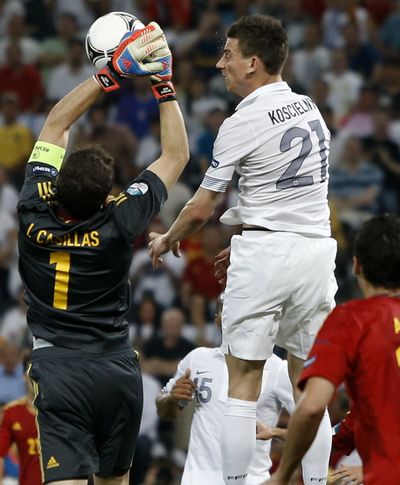 Spain goalkeeper Iker Casillas, left, and France’s Laurent Koscielny reach for the ball Saturday in Donetsk, Ukraine. (Associated Press)