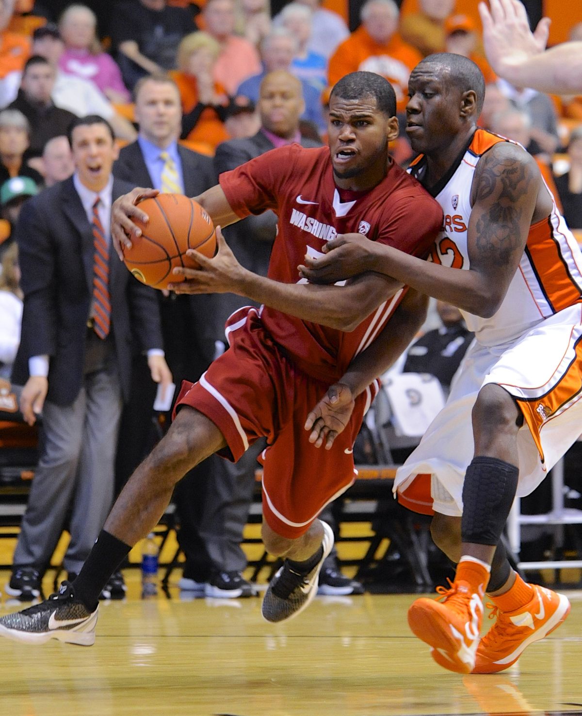 WSU’s Royce Woolridge drives against OSU’s Jarmal Reid. (Associated Press)