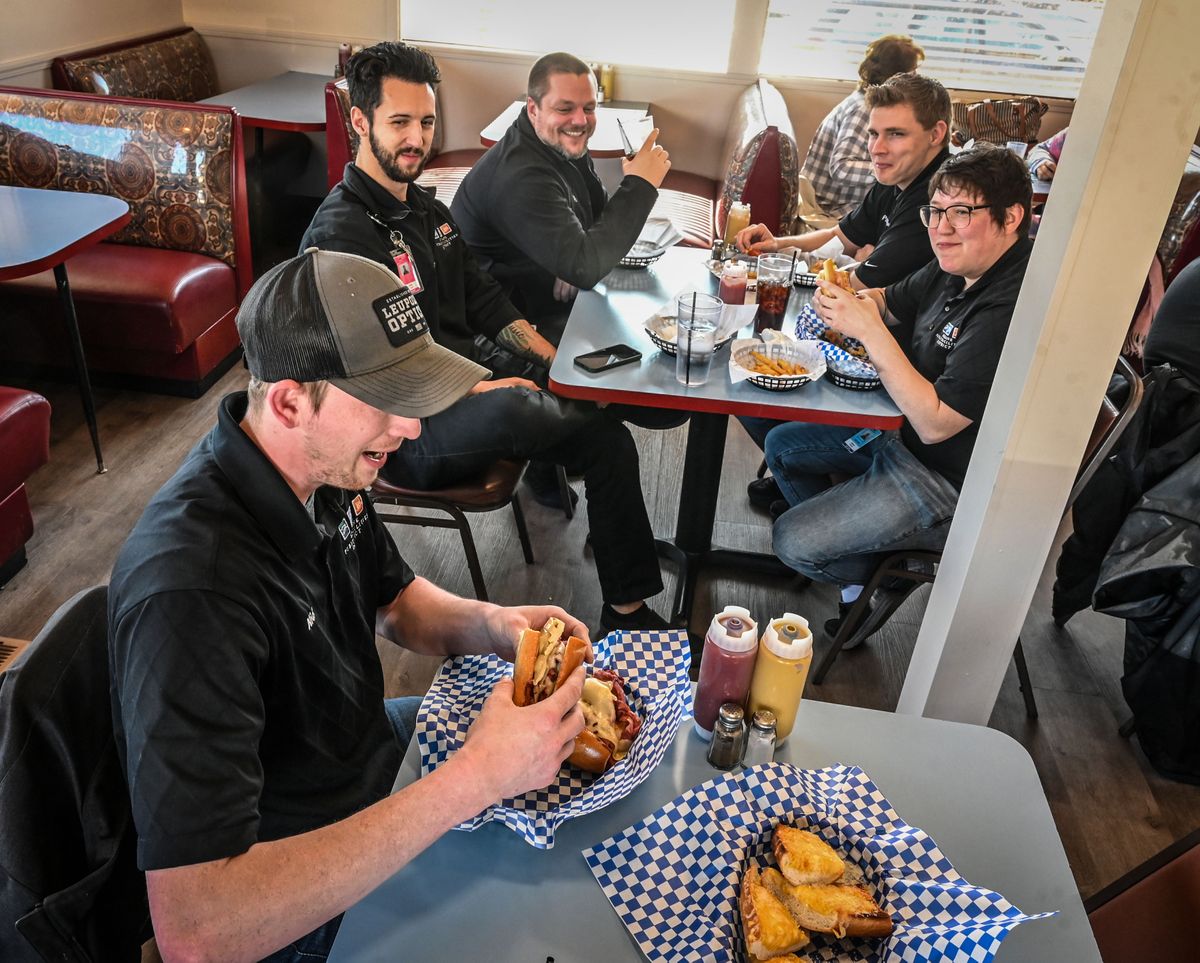 Nick Koch, lower left, digs into his hot pastrami sandwich as his co-workers from the Spokane Veterans Memorial Arena, from left, Caleb Cruze, Mike Sackville-West, Paxton Irving and Deanna Daniels look on during their first visit to Zozo’s Sandwich House on March 22. The business at 2501 N. Monroe St. is in the former Azars Restaurant.  (DAN PELLE/THE SPOKESMAN-REVIEW)