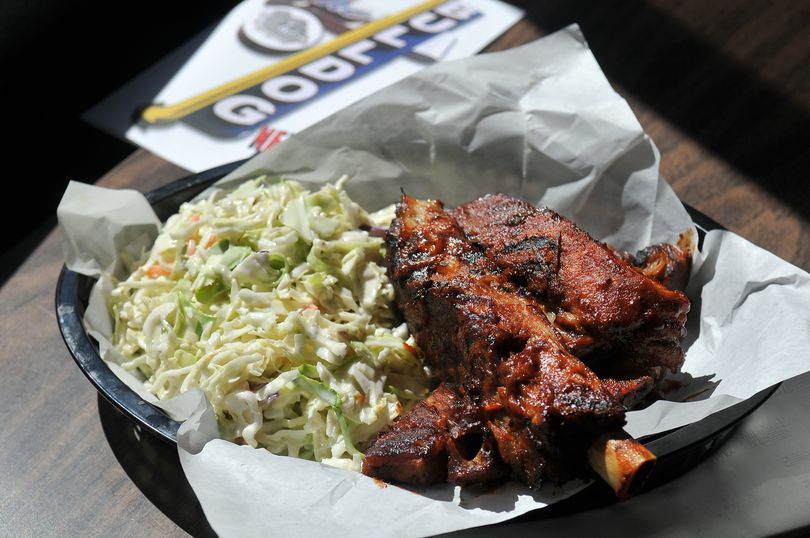 A pound of smoked ribs and pile of cole slaw are on the relatively new barbecue menu at the Bulldog Tavern near Gonzaga University in Spokane.  Chris Luce, a veteran barbecue pit boss, now cooks at the Bulldog and smoke various meats, even cheese and onions, for the new barbecue menu. (Jesse Tinsley / The Spokesman-Review)