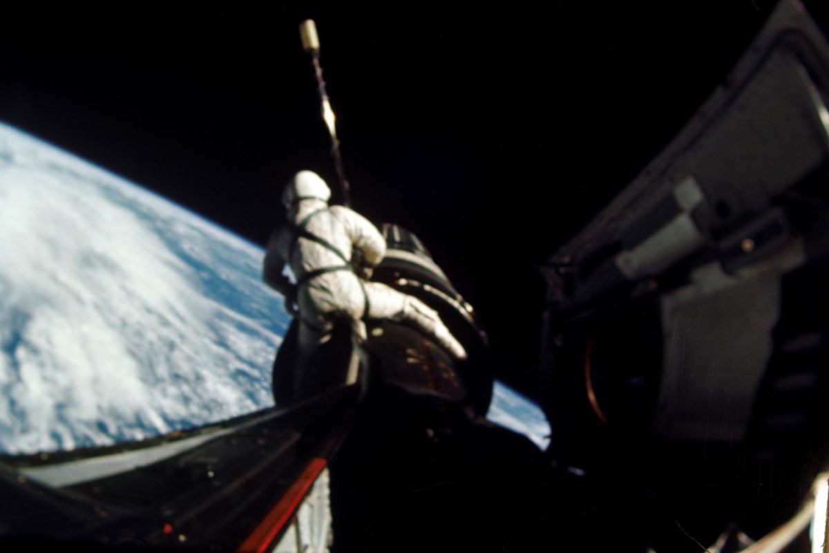 In this September 1966 photo provided by NASA, astronaut Richard F. Gordon Jr., pilot for the Gemini XI spaceflight, sits astride the spacecraft during a spacewalk, while attaching a tether from the Gemini capsule to the Agena vehicle. (Associated Press)