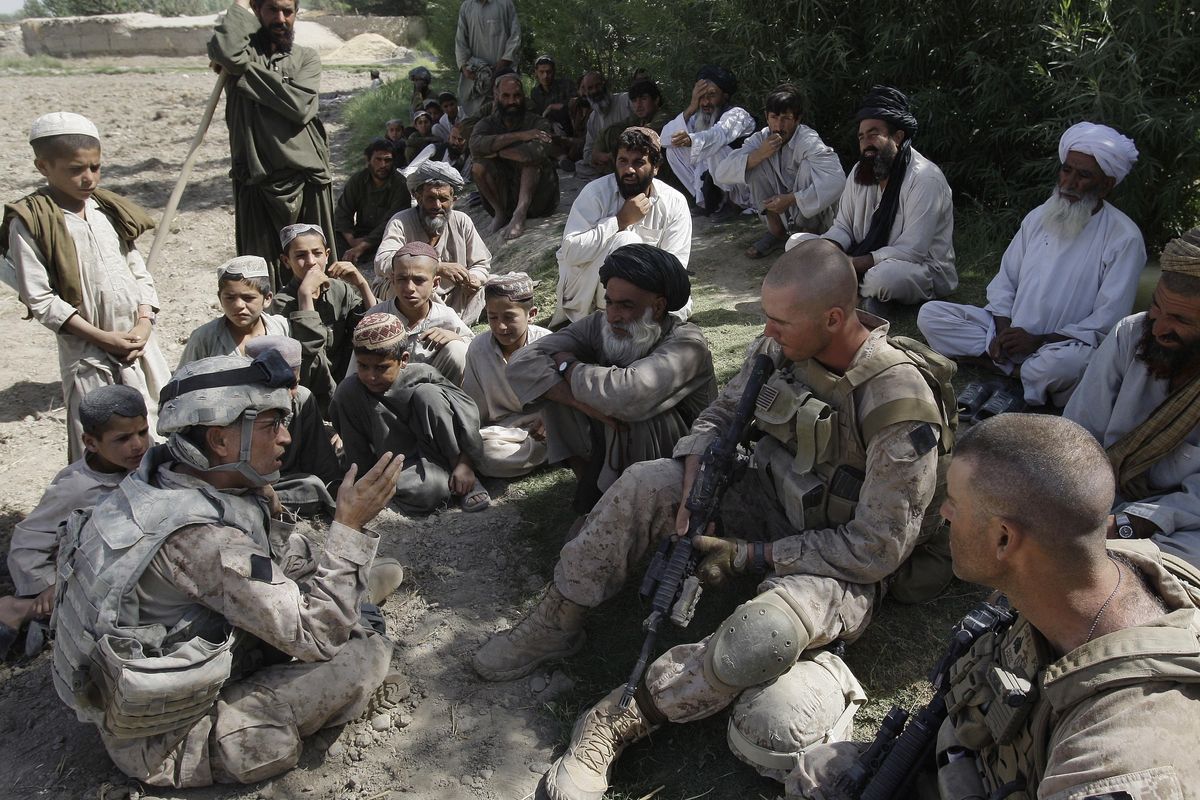 FILE - This July 2, 2009, photo shows Josh Habib, far left, a 53-year-old translator for the U.S. Marines, speaking with Afghan villagers and two Marines in the Nawa district of Afghanistan