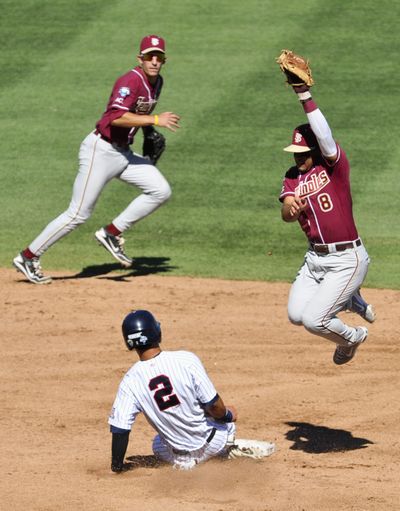 Arizona’s Robert Refsnyder steals second base as Florida State second baseman Devon Travis leaps for the ball. (Associated Press)