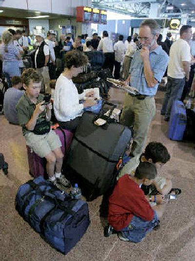 
Passengers with their baggage are line up for flights in Heathrow Airport in London. 
 (Associated Press / The Spokesman-Review)
