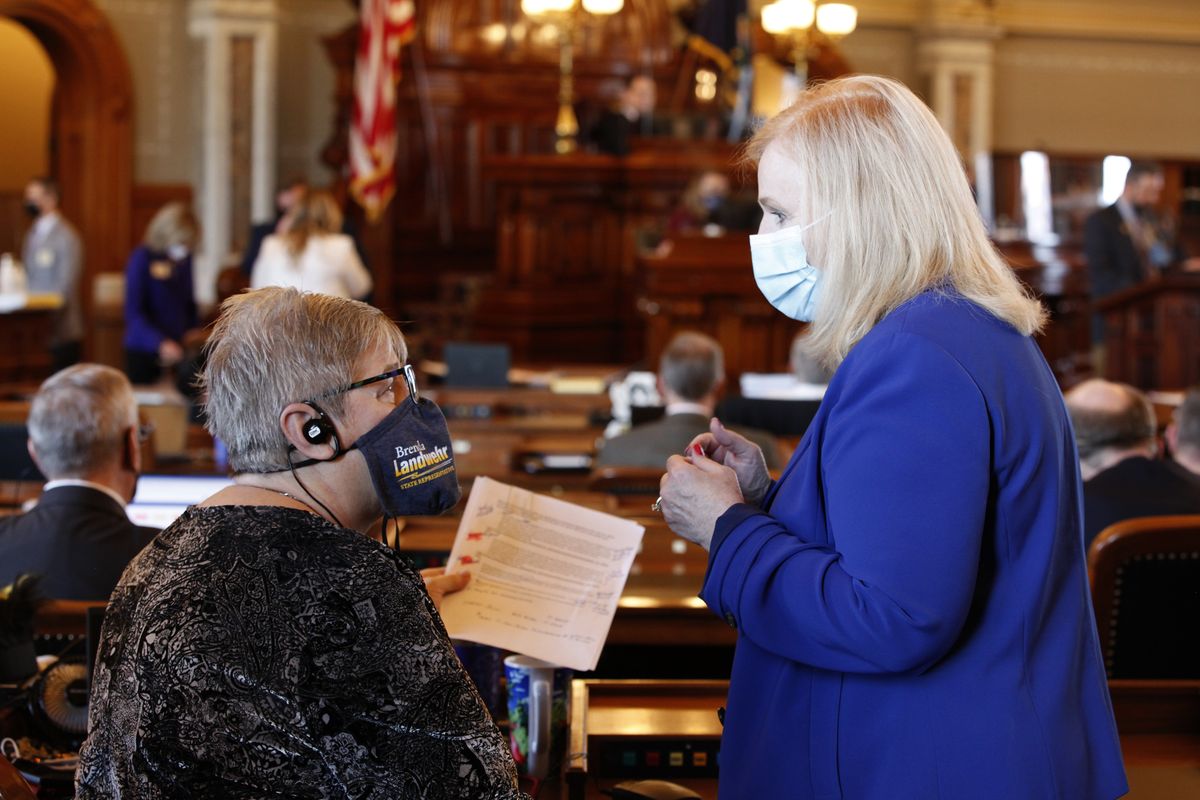 Kansas state Reps. Brenda Landwehr, left, R-Wichita, and Susan Concannon, R-Beloit, confer during a House debate on a proposed anti-abortion amendment to the Kansas Constitution, Friday, Jan. 22, 2021, at the Statehouse in Topeka, Kan. Both supported the measure, which would overturn a Kansas Supreme Court decision in 2019 that declared access to abortion a "fundamental" right under the state constitution.  (John Hanna)