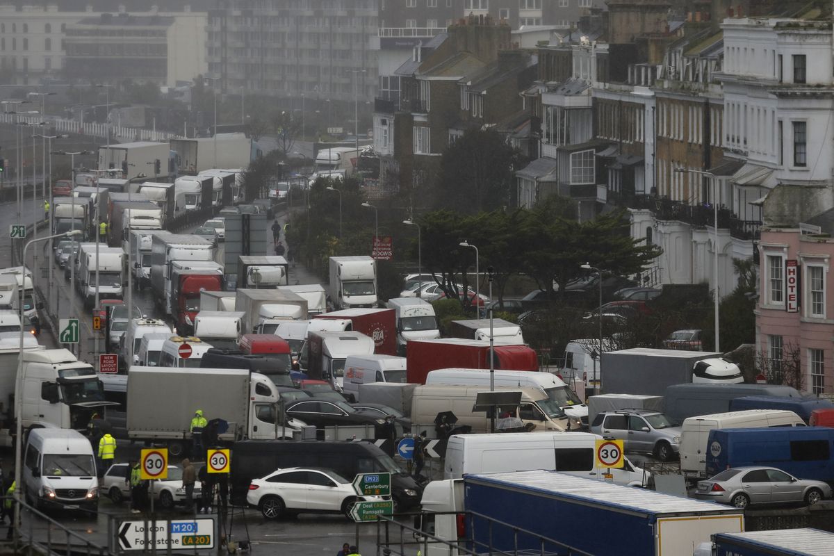 Vehicles wait at the entrance to the Port of Dover, that is blocked by police, as they queue to be allowed to leave, in Dover, England, Wednesday, Dec. 23, 2020. Freight from Britain and passengers with a negative coronavirus test have begun arriving on French shores, after France relaxed a two-day blockade over a new virus variant. The blockade had isolated Britain, stranded thousands of drivers and raised fears of shortages  (Frank Augstein)