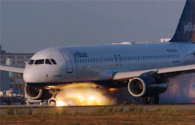 
Smoke and flames stream from the broken nose gear of a JetBlue Airbus 320 as it rolls out on its emergency landing at Los Angeles International Airport Wednesday. 
 (Associated Press / The Spokesman-Review)
