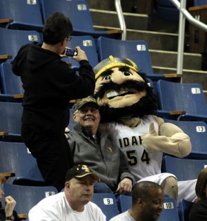 Darcy Pederson, left, takes a photograph of her husband, Ray, center, with Joe Vandal, the mascot of the Idaho Vandals during the first half of an NCAA basketball  game against Fresno State at the Western Athletic Conference tournament in Reno, Nev., Friday, March 12, 2010. (Rich Pedroncelli / Associated Press)