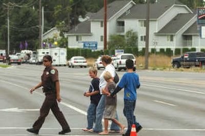 
Kootenai County sheriff's Deputy Alana Hunt directs evacuees away from the Park Place Apartments on Wednesday after a shooting closed parts of the complex. 
 (Jesse Tinsley / The Spokesman-Review)