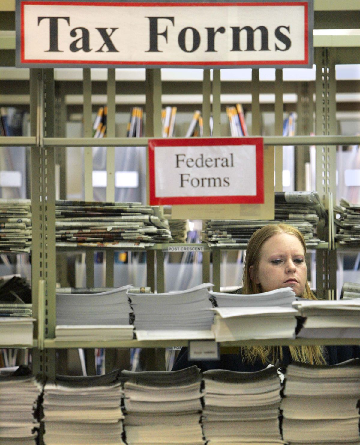 A taxpayer looks over tax forms at a library.  (File Associated Press / The Post-crescent)