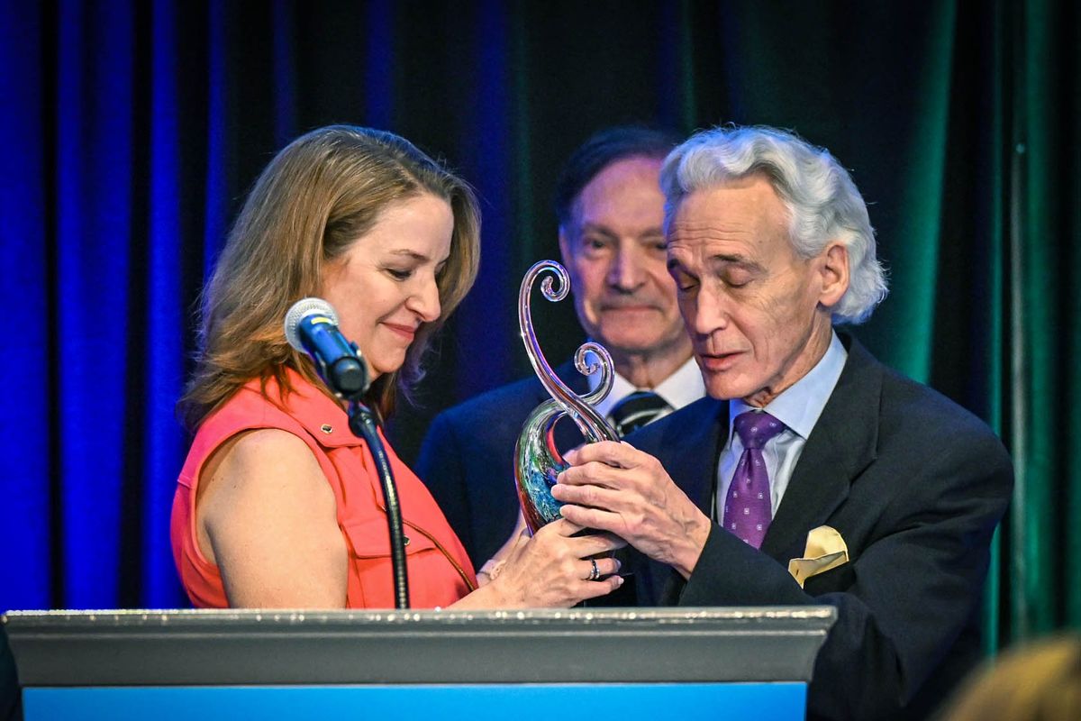 Spokane County Commissioner Mary Kuney presents long-time county employee and chief civil prosecutor Jim Emacio with a lifetime achievement award during the State of the County address on Thursday at the Spokane Convention Center.  (DAN PELLE/THE SPOKESMAN-REVIEW)