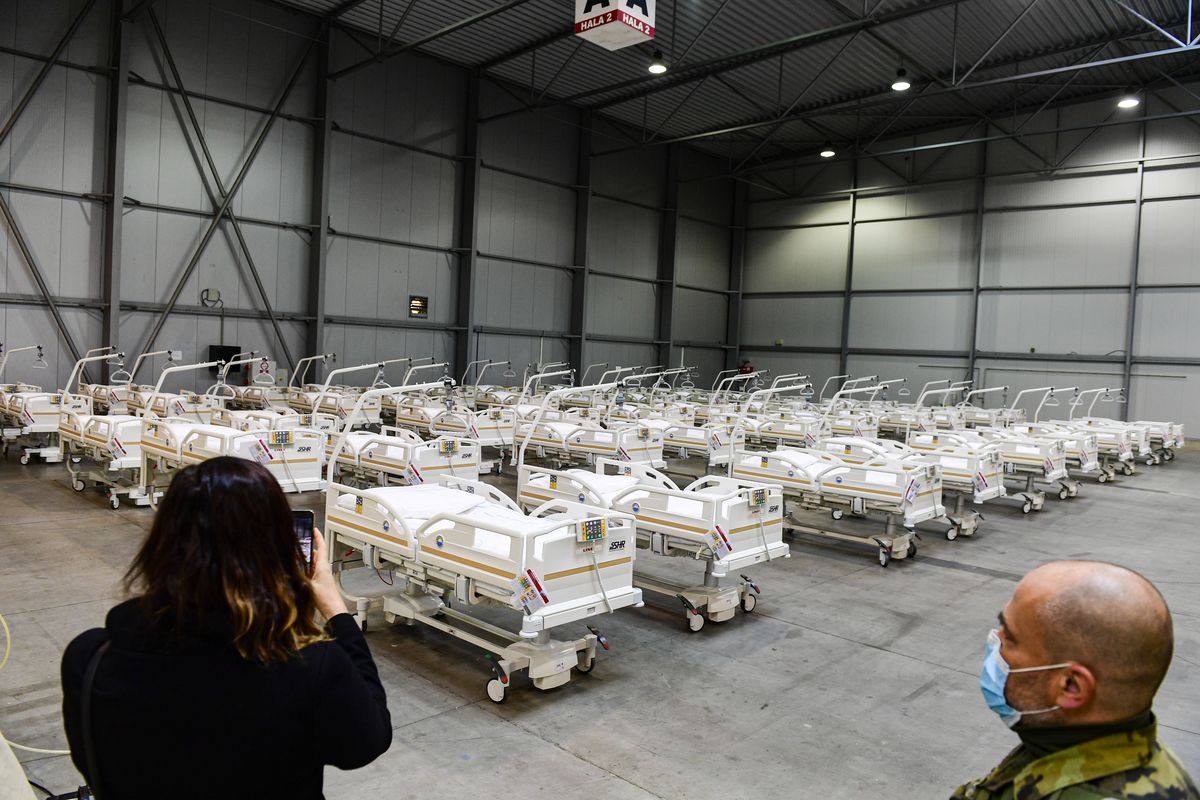 A journalist takes a picture of beds prepared in a field hospital, which will function as a backup device for patients with coronavirus, in the Letnany neighbourhood at the Prague outskirts, Czech Republic, Thursday, Oct. 22, 2020. SLOVAKIA OUT  (Roman Vondrous)