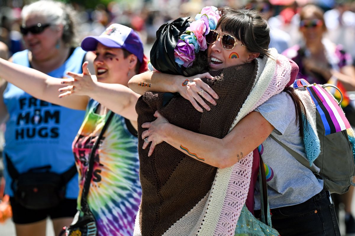 Asra Hill, left, darted from the crowd and into the 2025 Spokane Pride Parade to hug Whitney Tampien, right, as they parade turned onto Spokane Falls Boulevard on Saturday, Jun. 14, 2025, in downtown Spokane, Wash.  (Tyler Tjomsland/The Spokesman-Review)