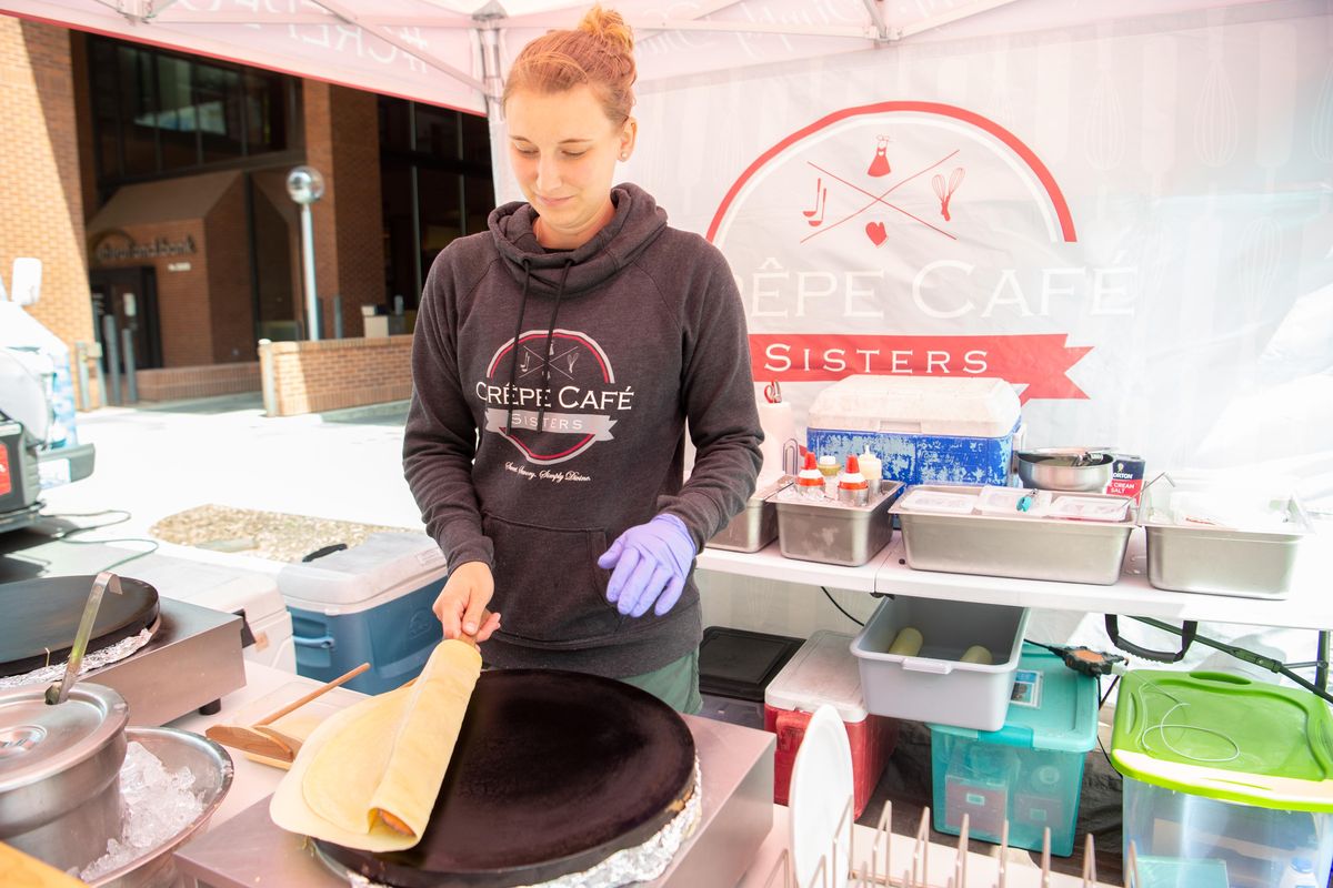 Amber Robillard of Crepe Cafe Sisters carefully folds a crepe during the July 19 lunch hour gathering of Spokane Food Truck Association members in downtown Spokane. The Association organizes food truck gatherings, but also ways to give back, including chances to food the homeless at various events. (Jesse Tinsley / The Spokesman-Review)