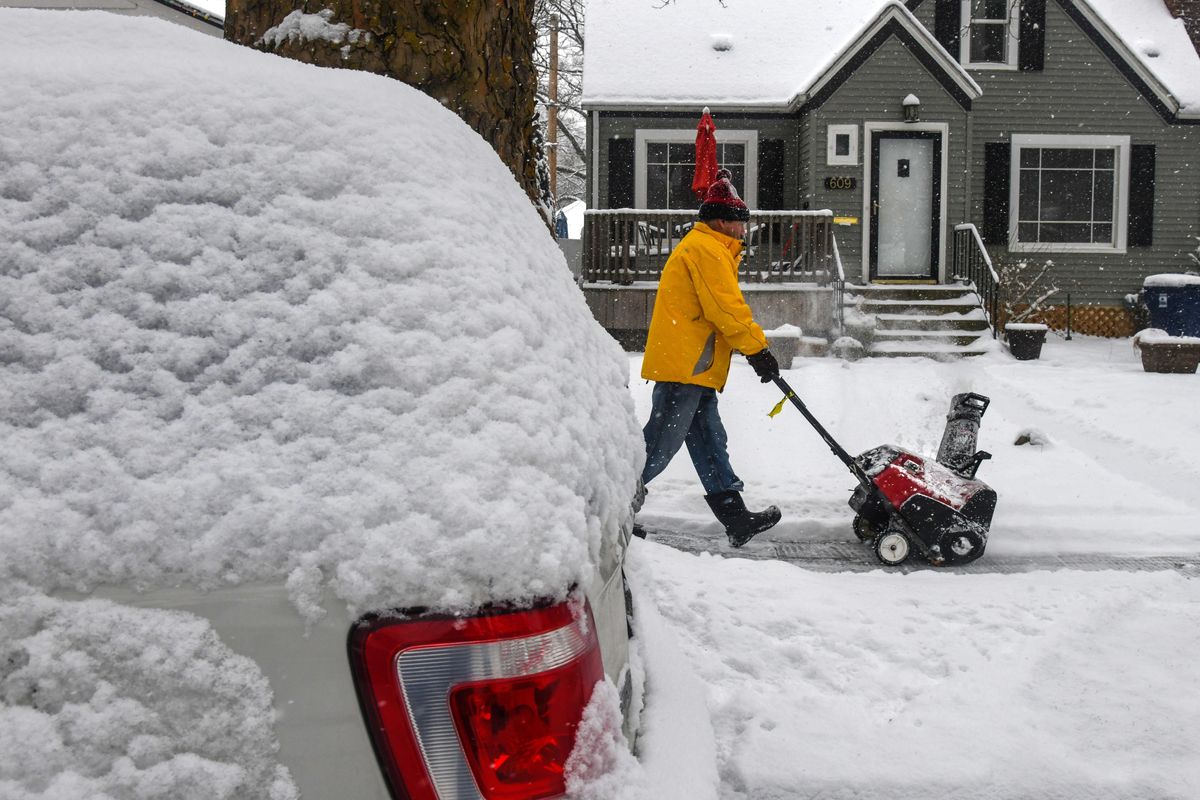 Todd Edmonds came back on Wednesday from Puerto Vallarta and 77 degrees to snow-covered Spokane as he clears the sidewalk for his daughter-in-law, Friday, Feb. 8, 2019, along 18th Avenue. (Dan Pelle / The Spokesman-Review)