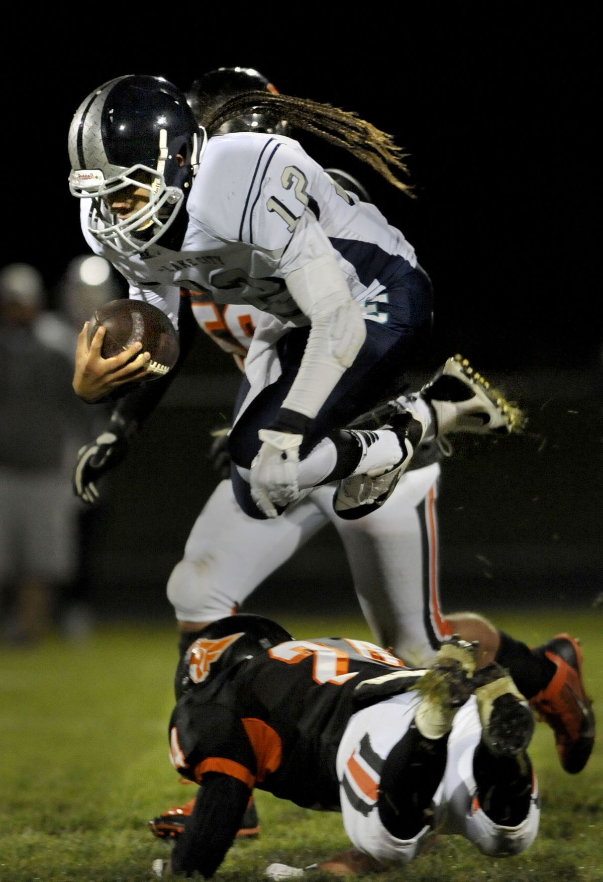Lake City's quarterback, Tucker Louie-McGee hurdles Post Falls defense in the first half of the game at Post Falls High School on Friday, Sept. 27, 2013. (Kathy Plonka)