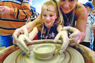 
Teacher Anne Couser pulls the hands of Charlotte Romero, 5, away from her clay to show her how she had transformed it into a dish at the mARTi Gras Kids Carnival on Saturday in Coeur d'Alene. The event featured art projects and experiences for kids and performances by student groups.
 (Jesse Tinsley / The Spokesman-Review)