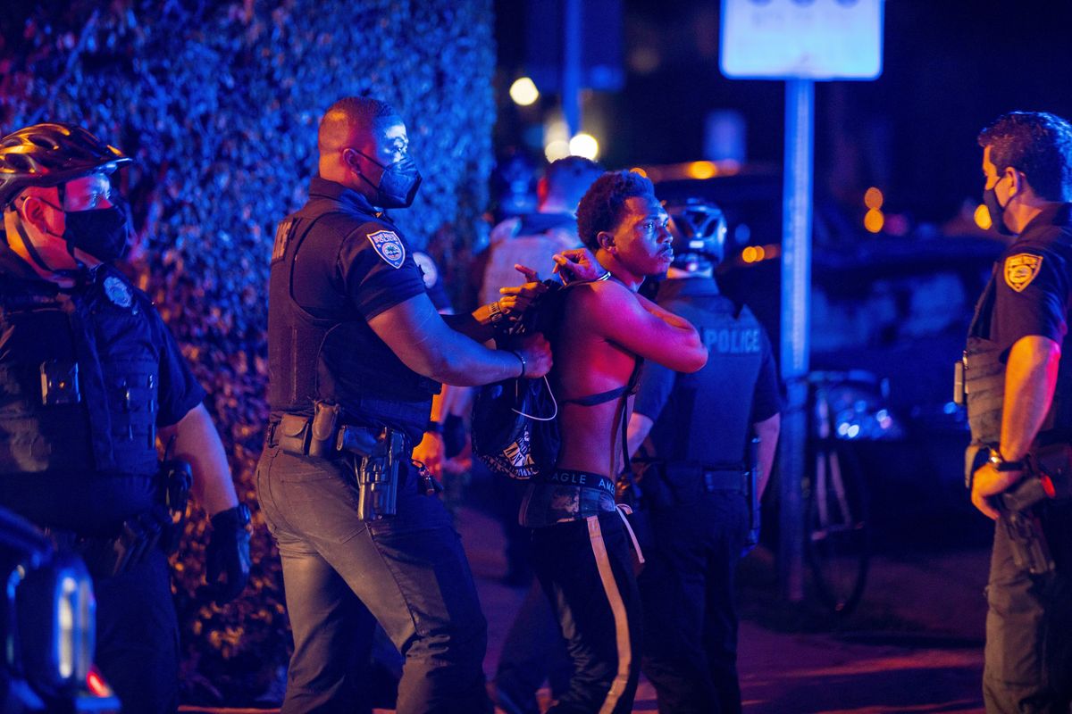 A person is arrested while out a few hours past curfew in Miami Beach, Fla., on Sunday, March 21, 2021. Miami Beach commissioners voted unanimously Sunday to extend the 8 p.m. to 6 a.m. curfew Thursday through Sunday in the South Beach entertainment district until at least April 12.  (Daniel A. Varela)