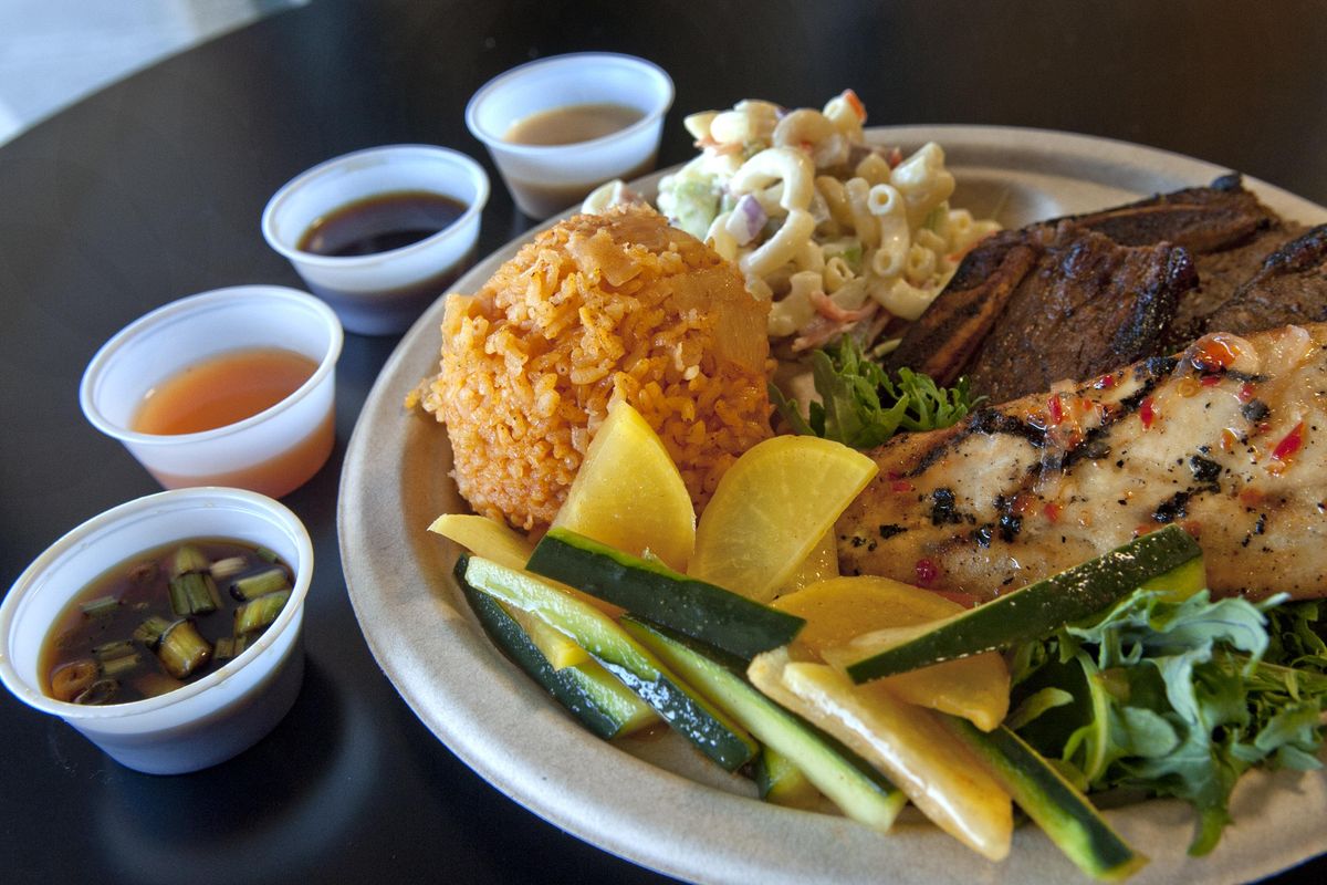 Big Island BBQ’s regular mixed plate comes with two main dishes, two salads and a scoop of rice. It’s pictured here with island macaroni salad, BBQ short ribs, grilled mahi-mahi, cucumber Diago salad, fiesta red rice and an array of sauces. (Kathy Plonka / The Spokesman-Review)
