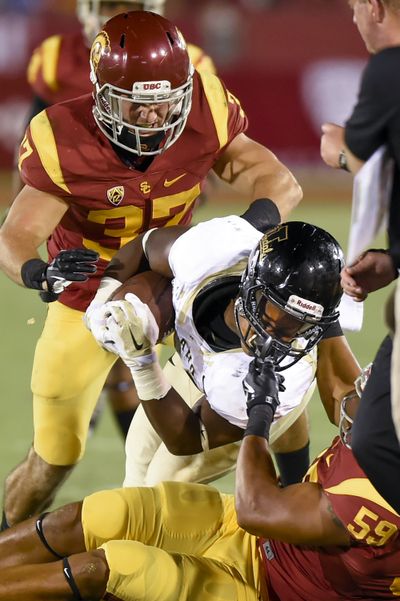 USC linebacker Don Hill, bottom right, pulls down Idaho RB Aaron Duckworth. (Associated Press)