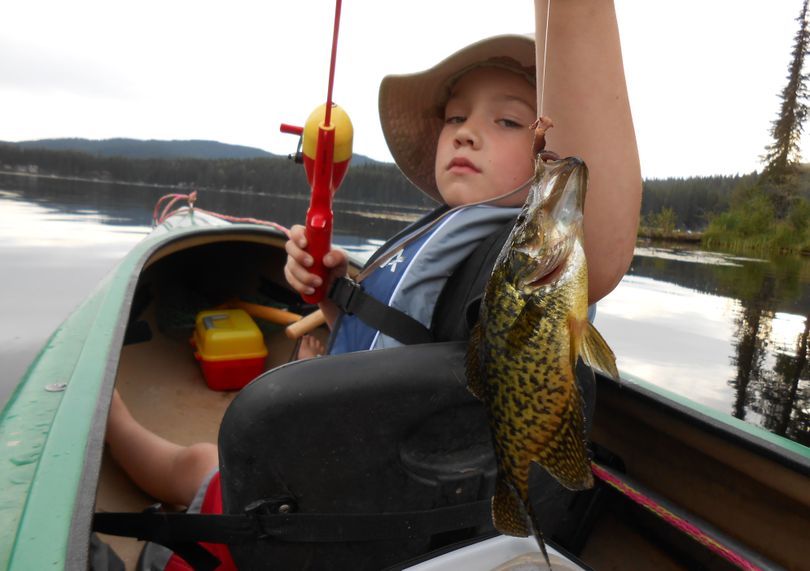 Jamie McMurtery, 6, hauls in a crappie from Lake Thomas during a summer camping trip with his dad, Jeff.