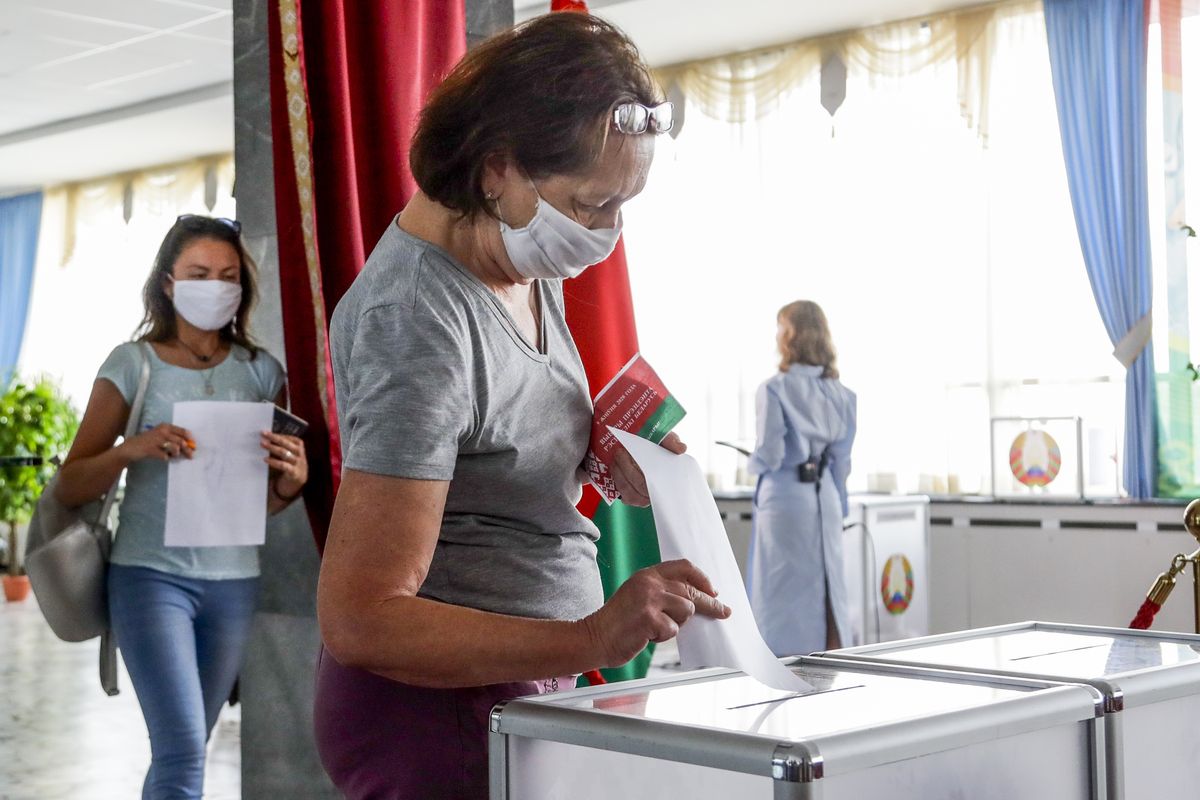 FILE - In this Aug. 9, 2020, file photo, a woman casts her ballot at a polling station during the presidential election in Minsk, Belarus, Sunday, Aug. 9, 2020. In the three weeks since the election that kept President Alexander Lukashenko in power, hundreds of thousands of people have protested what they say was a rigged outcome. (Sergei Grits)