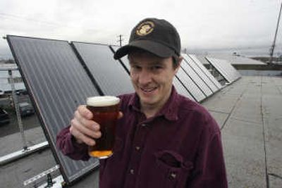 
Lucky Lab Brewing Co. co-owner Gary Geist raises a beer on the roof of the company's lab Friday in Portland. Lucky Lab is the first brewery in Oregon to use solar panels to brew its beer. Associated Press
 (Associated Press / The Spokesman-Review)