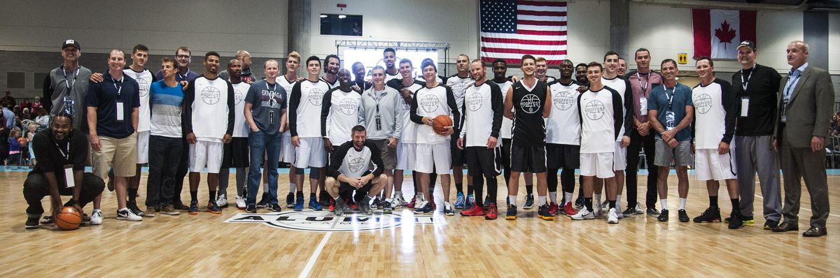 Former Gonzaga basketball players gather on the court at the Spokane Convention Center before the alumni game. (Dan Pelle / The Spokesman-Review)