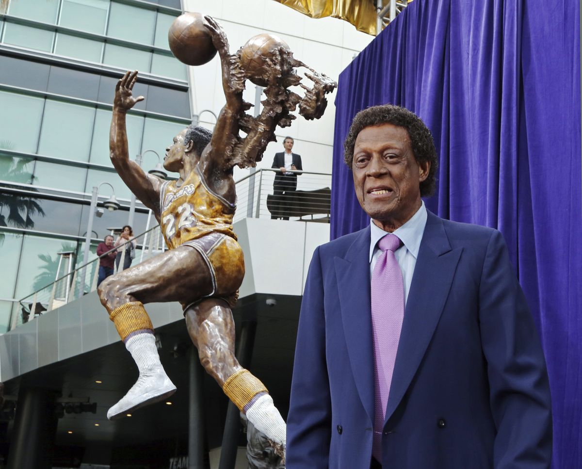 Elgin Baylor stands next to a statue, just unveiled, honoring the Minneapolis and Los Angeles Lakers great, outside Staples Center in Los Angeles, in this Friday, April 6, 2018 photo. Elgin Baylor, the Lakers’ 11-time NBA All-Star, died Monday, March 22, 2021, of natural causes. He was 86.   (Reed Saxon)