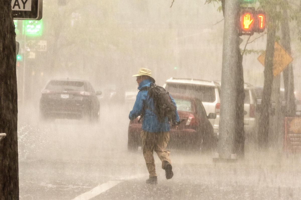 A pedestrian crosses Lincoln Street in the midst of a drenching downpour late Thursday, May 16, 2019, in downtown Spokane. (Jesse Tinsley / The Spokesman-Review)