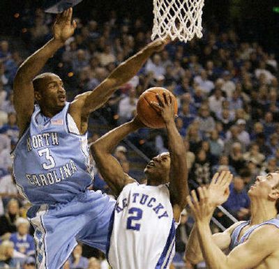 
North Carolina's Reyshawn Terry leaps high to block the shot of Kentucky's Ravi Moss on Saturday. 
 (Associated Press / The Spokesman-Review)