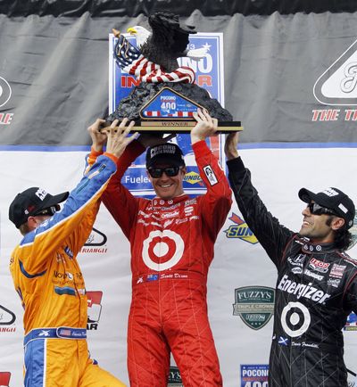 Scott Dixon, center, Charlie Kimball, left, and Dario Franchitti hoist trophy. (Associated Press)