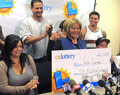 Julie Cervera, third from left, is surrounded by family members as she holds a $23 million dollar prize banner for the media in San Bernardino, Calif. (Associated Press)
