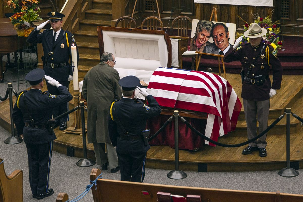 A man pays his respects at the public viewing for former Democratic U.S. senator and three-time presidential candidate George McGovern at the First United Methodist Church in Sioux Falls, S.D., as an honor guard salutes , Thursday, Oct. 25, 2012. McGovern died Sunday in his native South Dakota at age 90. (Nati Harnik / Associated Press)