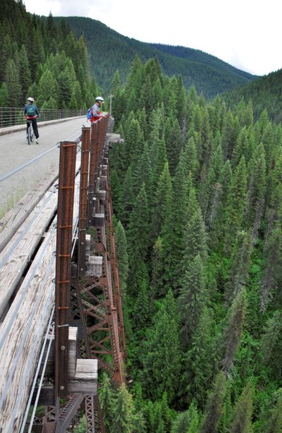Bicyclists peer off the Kelly Creek trestle, the tallest of seven along the Hiawatha rail-trail route.